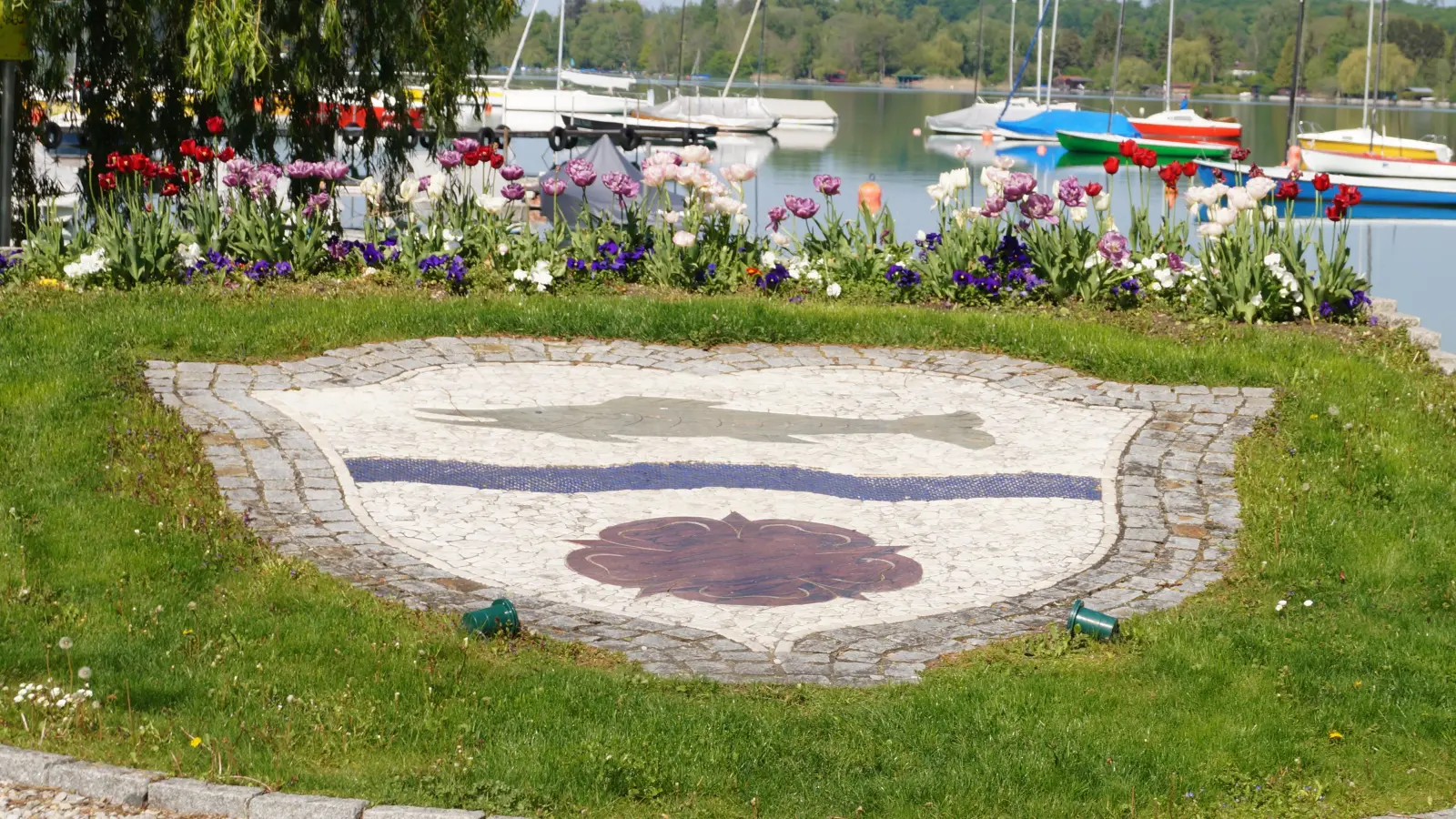 Das Gemeindewappen der 50 Jahre alten Gemeinde Wörthsee als dekoratives Element in der Blumenrabatte am Seeufer.  (Foto: pst)