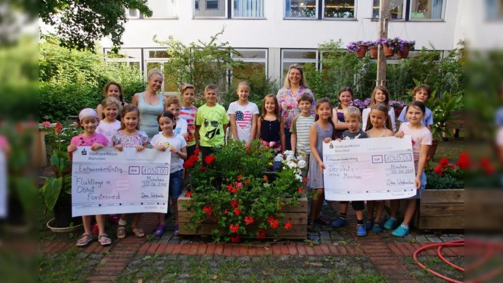 Stolz präsentieren die Kinder die Spendenchecks, die an Flüchtlinge in Obhut und den Tierschutzverein München gehen. Dana Wodianka (hinten, 2. v.l.) und Gabriele Reitsam (hinten, 4. v.r.) vom Elternbeirat gehören zu den Veranstaltern des Laufs. (Foto: jw)