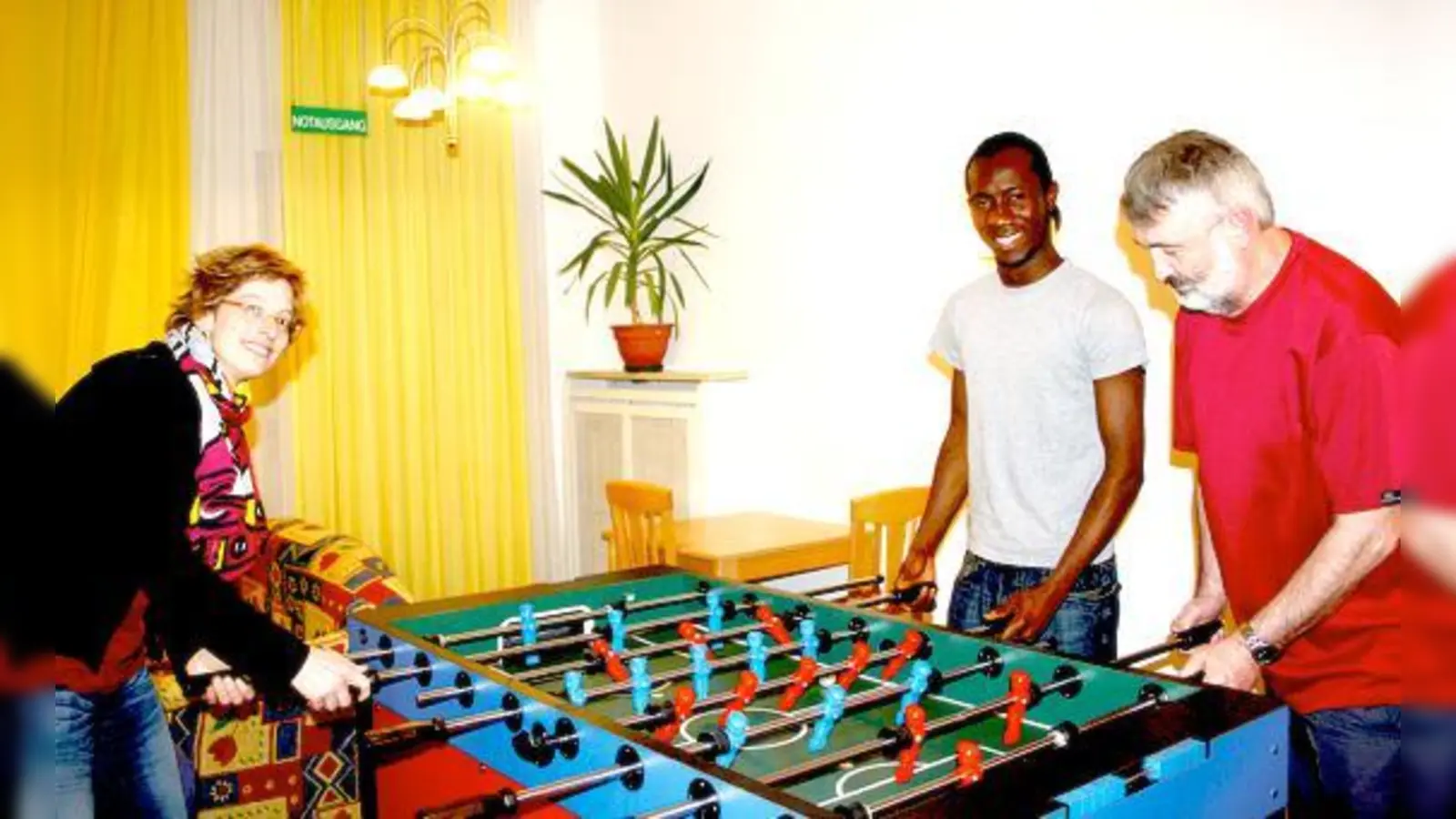 Abdul Karim Kabbia (Mi.) im Gemeinschaftsraum beim Kickern mit Einrichtungsleiterin Sabine Hodek und Christoph Stenger vom Jugendamt.	 (Foto: js)