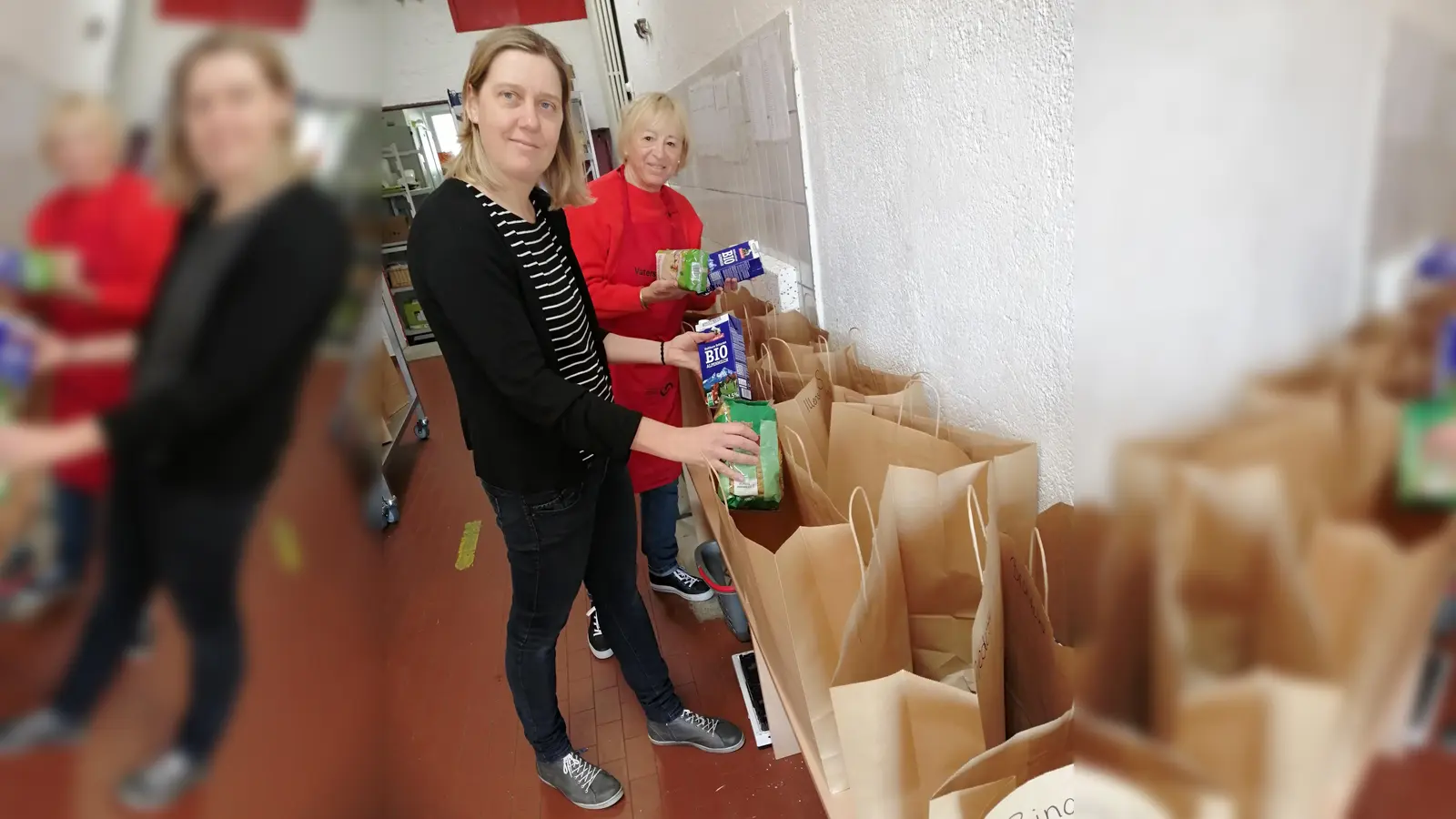 Für jeden Haushalt eine Tüte: Julia Haigis und Tafelhelferin Regine Cagic im Laden der Tafel Vaterstetten. (Foto: Nachbarschaftshilfe)