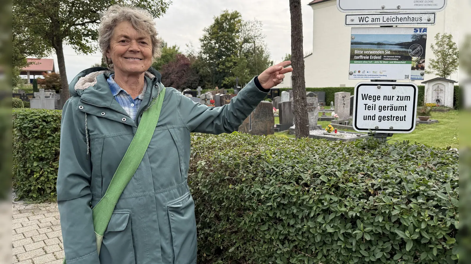 Isolde Schramm-Warmke vor der Tafel, die auf dem Argelsrieder Friedhof für torffreie Erde wirbt.  (Foto: pst)