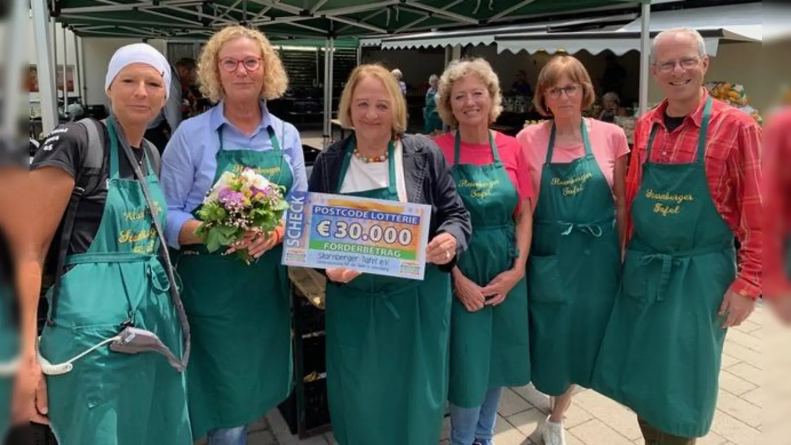 Erika Ardelt (mit Blumen) und der gesamte Tafel-Vorstand bei der Übergabe des Schecks durch Sabine Leutheuser-Schnarrenberger. (Foto: Starnberger Tafel)