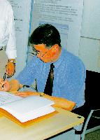 Li Chengchang trägt sich unter den Augen von Bürgermeister Rolf Zeitler in das Goldene Buch ein.
	Foto: ms