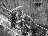Kunstschmied Josef Forstmeier und seine Kollegen bringen nach und nach die schmiedeeisernen Dachreiter auf dem Rathausdach an. 	Fotos: ms