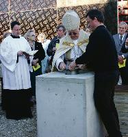 Weihbischof Engelbert Siebler versenkt eine Kapsel mit Zeitzeugnissen im Grundstein des neuen Dominikuszentrums an der Nordheide. Foto: au