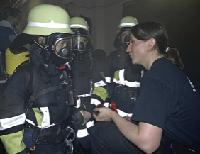 Sogar in die schwere Feuerwehrmontur durften die Mädchen, hier mit Tanja Ramian, Stadtjugendleiterin der Freiwilligen Feuerwehr, schlüpfen. F.: Feuerwehr