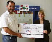 Schulleiter Günther Bartl nimmt den Scheck dankend von Bettina Schmid von der Raiffeisenbank entgegen. Foto: VA