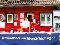 Nicola Fallack, Jugendleiterin bei der Wasserwacht Unterhaching, gemeinsam mit ihrer Unterstützung, Lennart Martens, am Informationsstand der Wasserwacht Unterhaching vor dem Wasserwacht-Häuschen auf dem Gelände des Freibads.