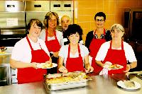 Leckere Mahlzeiten bringt das Team um Mensa-Betreiberin Martina Berg (Bildmitte) für die Schüler und Lehrer auf den Tisch. Foto: hol