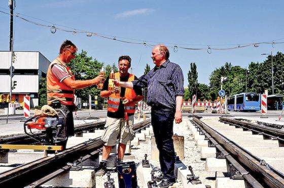 Mit Apfelschorle stieß Andreas Nagel (r.) mit Bauarbeitern auf das erste Gleisstück der Neubaustrecke nach St. Emmeram an. 	Foto: Aktion Fahrgäste