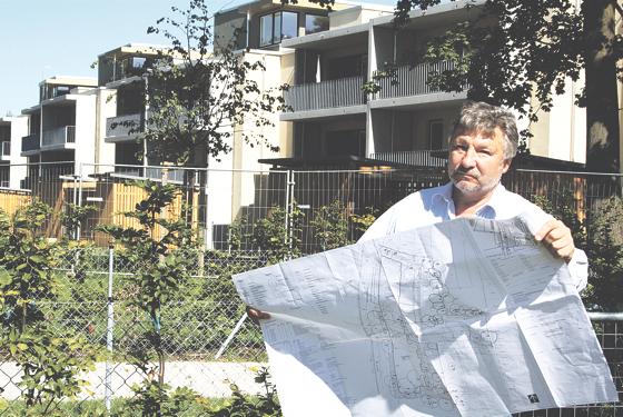 Heinz Gutbrunner mit dem aktuellen Bebauungsplan vor den Neubauten in der Maikäfersiedlung. Weitere Häuser mit Flachdach lehnt die IG ab.	Foto: js