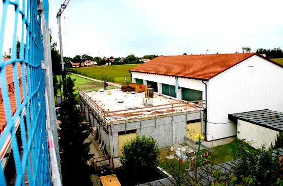Blick vom neu gedeckten Dach des Schulhauses auf den entkernten Zwischentrakt, der Anfang Oktober aufgestockt wird. Rechts die Turnhalle.	Foto: gh