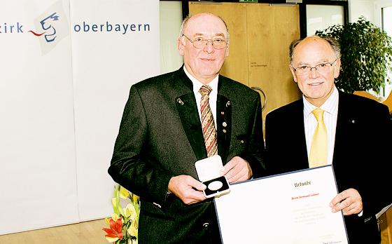 Hermund Göttner (li.) bei der Überreichung der  Medaille und Urkunde durch Bezirkstagspräsident  Josef Mederer.	Foto: Bezirkstag