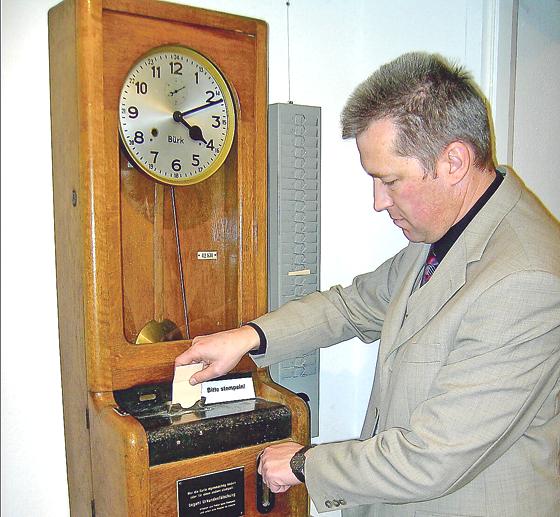 Museumsleiter Bernhard Schäfer demonstriert die Registrierung der Arbeitszeit an einer Stechuhr aus dem 19. Jahrhundert. Foto: oh