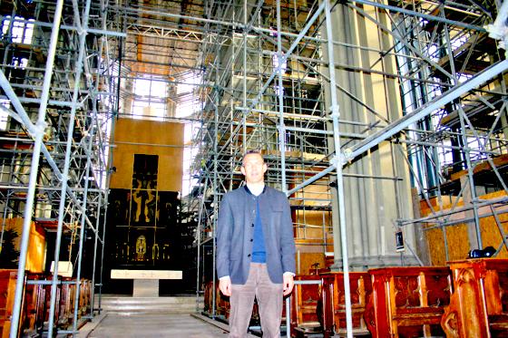 Pfarrer Engelbert Dirnberger inmitten seiner Großbaustelle im Innern der Giesinger Heilig-Kreuz-Kirche, die noch bis Ende 2014 andauern wird.	Foto: Hettich