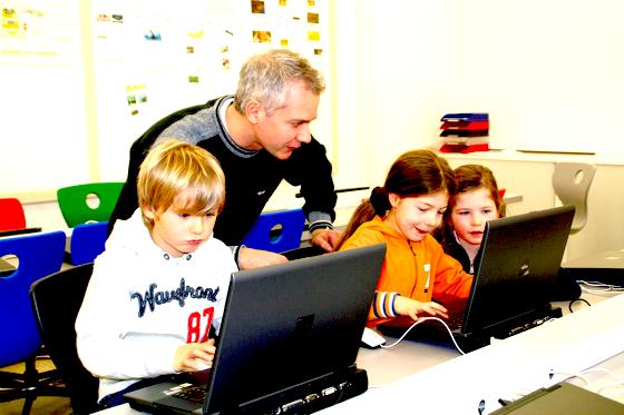 Bestens ausgerüstet ist der Computerraum der Martin-Kneidl-Schule. Systemadministrator Philipp Wynne erklärt Kindern, wie man am PC arbeitet. 	Foto: hol