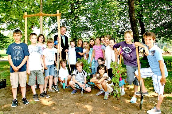 Mit Begeisterung pflanzen Kinder der Martin-Kneidl-Schule gemeinsam mit Bürgermeister Jan Neusiedl Büsche zur Begrünung des Spielplatzes.	Foto: hol