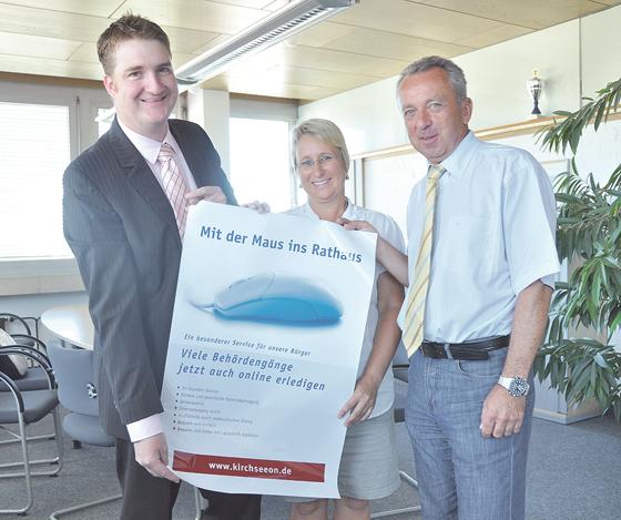 Marco Vogl, Sabine Koepp und Bürgermeister Udo Ockel (v.l.) präsentieren das Plakat, das auf den neuen Online-Service des Rathauses hinweist.  	Foto: sf