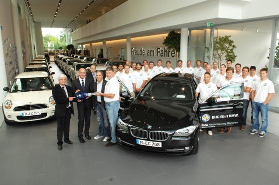 Jürgen Bochanski (EHC), Dirk Kemmer (BMW), Thomas Kriner (EHC) und Pat Cortina (EHC, vorne v. li.)  mit dem gesamten Spielerkader des EHC München.	Foto: BMW