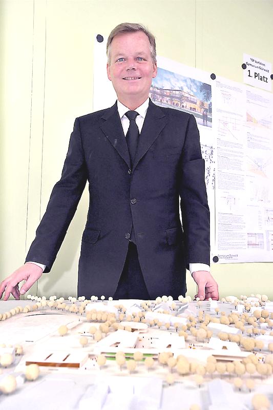 Bürgermeister Jan Neusiedl mit dem Modell des geplanten Gymnasiums.	Foto: Schunk