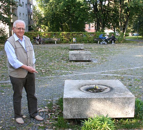 Franz Kexel vom Bezirksausschuss Feldmoching-Hasenbergl steht vor einem der maroden Brunnenquader auf dem Platz in der Gustav-Schiefer-Straße. 	ws