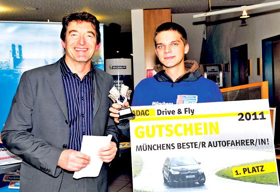 Münchens bester Autofahrer, Daniel Huber, bekam von Ernst Kreisl (Münchner Wochenanzeiger) den Siegerpokal und den Gutschein für das ADAC Drive & Fly-Paket.