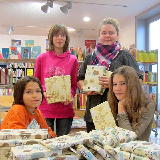 Noah, Susanne, Jessica und Verena (von links) aus den siebten Klassen der Mittelschule am Lodererplatz halfen, die Bücher zu verpacken. Foto: Stadt Erding