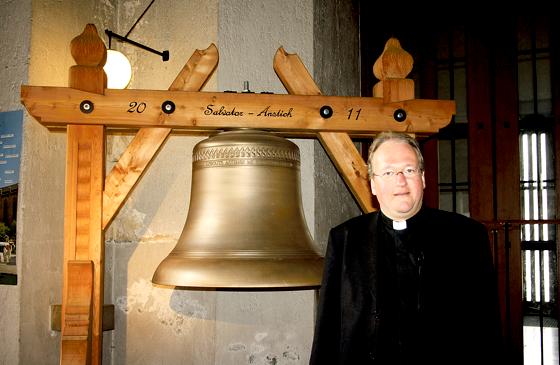Pfarrer Markus Gottswinter lädt dazu ein, sich eine Glocke aus der Nähe zu betrachten. Ihre 65 »Schwestern« hängen schon im Turm.	Foto: Julia Stark