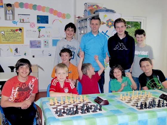 Der Jugendleiter des Unterhachinger Schachclubs, Peter  Dengler, inmitten der schachbegeisterten Jugend.