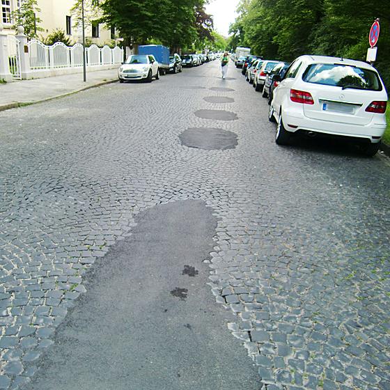 Die Holperstrecke Maria-Theresia-Straße, die an vielen Stellen notdürftig geflickt ist, soll auf Antrag der CSU im BA instand gesetzt werden. Foto: ikb