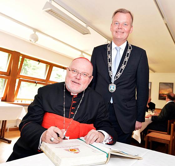 Erzbischof Kardinal Reinhard Marx trug sich auf Einladung von Bürgermeister Jan Neusiedl ins Goldene Buch der Gemeinde Grünwald ein. Foto: Schunk
