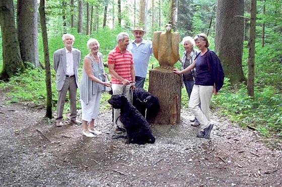 Die Teilnehmer mit ihren vierbeinigen Lieblingen herumgruppiert um den aus einem Baumstamm geschnitzten Adler auf dem neu hergerichteten Waldlehrpfad. 	Foto: VA