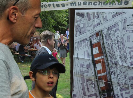 Besucher Hogenschurz mit Sohn Nino begutachten den gültigen Bebauungsplan, der durch das Vorhaben der Stadt jetzt geändert werden soll. 	Foto: Privat