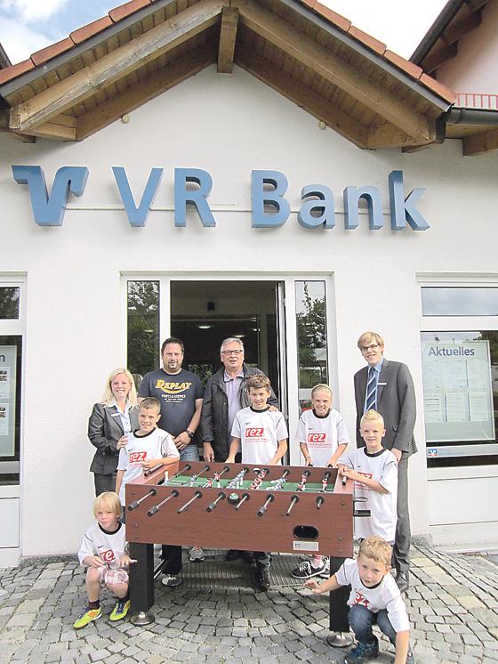 Karin Schmid von der VR Bank übergab den Kickertisch an Michael und Ewald J. Matejka (hinten von links) sowie eine Gruppe von Junioren-Fußballern des SV Heimstetten.	Foto: SVH