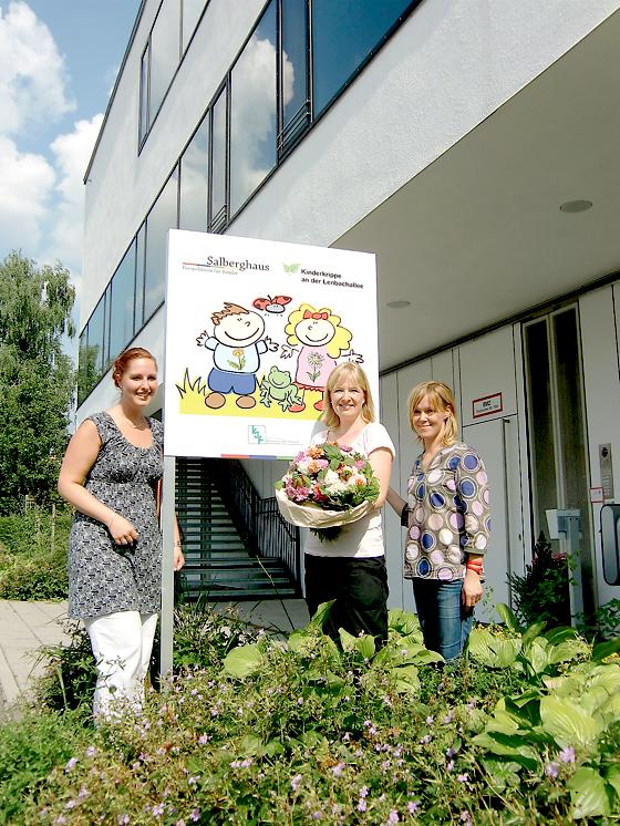 Einrichtungsleiterin Alexandra Kosow (links), Grafikerin Nina Tines (Mitte) und Barbara Grämmel vom Elternbeirat präsentieren stolz das neue Schild.	Foto: privat