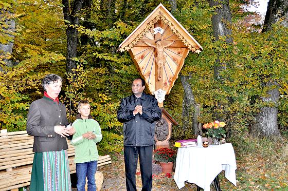 Elisabeth Reis schnitzte selbst das „Südkreuz“ am Waldrand von Buch, hier mit dem Ministranten Kilian und Pater Georg bei der feierlichen Weihe. 	Foto: sf