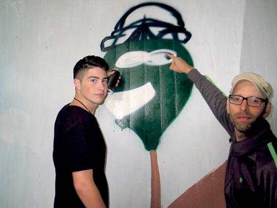 Da der Künstler Loomit plötzlich ausfiel, hilft Projektleiter Christoph Schmidmeier (rechts) einem Jugendlichen beim Graffiti-Malen.	Foto: aha