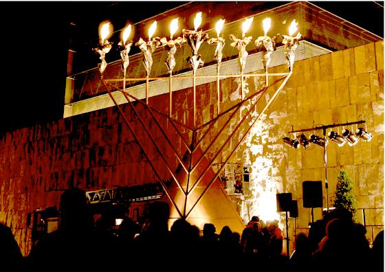 Mithilfe der Feuerwehr wird der große Leuchter vor der Münchner Synagoge entzündet. Foto: VA