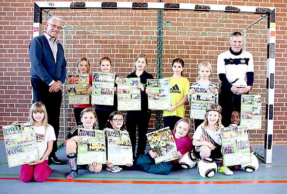 JFG-Chef Hans Egger (l.) und Übungsleiter Norbert Göbeler (r.) brachten den Mädchen vom Lodererplatz den Erdinger Fußballkalender mit, in dem auch die beiden Sport-nach-1-Mannschaften zu sehen sind. 	Foto: Priglmeir