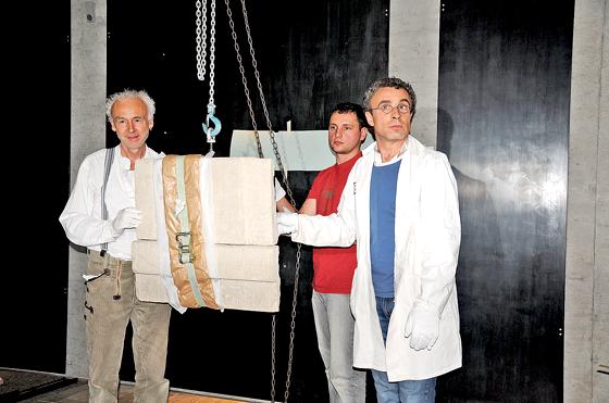 Restaurator Michael Pfanner (links) und Kollegen hängen die ersten Objekte im neuen Museum auf, hier eine sogenannte Scheintür zum Jenseits.	Foto: Museum