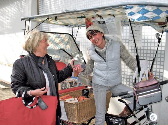 Büchertausch und Kontaktbörse: Die Rikscha am Waldheimplatz ist ein beliebter Treffpunft, hier mit, Christine Gruzlewski (r.) und eine Bürgerin. 	Foto: Boschert