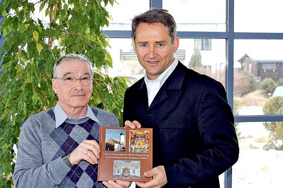 Dr. Anton Martin und Bürgermeister Stefan Kern mit einem Exemplar der Kirchenchronik.	Foto: VA