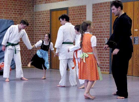 Bei den Aufwärmübungen und bei der Siegerehrung: auch im Dirndl kann man prima an Karateprüfungen teilnehmen.	Foto: VA