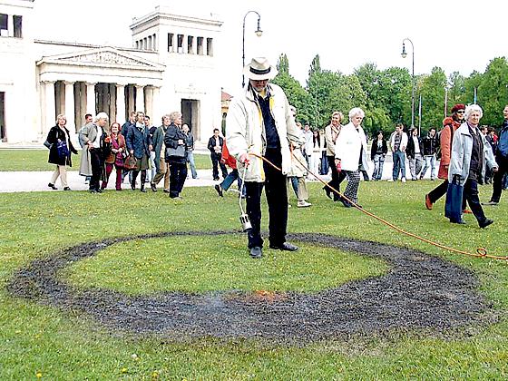 »Damit kein Gras über die Sache wächst«: Der Künstler Wolfram P. Kastner verbrennt ein Stück Rasen am Königsplatz.	Foto: privat