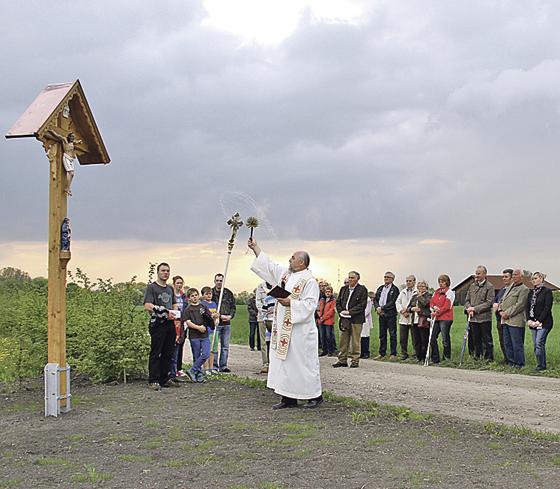 Das Feldkreuz strahlt in neuem Glanz, und einen neuen Platz hat es auch bekommen. Pfarrer Joschko bei der Weihe.Foto: privat
