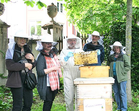 Harald Weiß (3. v. l.) und Ralf Armbrecht zeigen Johanna Brechtken (2. v. l.)  und zwei Schwabingerinnen eine Honigzarge im Garten der Seidlvilla. 	Foto: scy