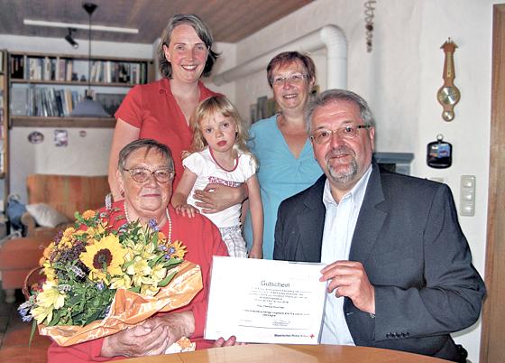 Wolfgang Strehhuber überreichte Therese Purschke einen Gutschein und Blumenstraus. 	Foto: BRK