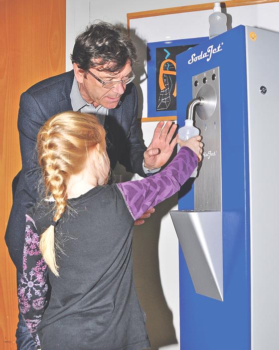 Bürgermeister Albert Hingerl testet zusammen mit einer Schülerin den neuen Wasserspender in der Schule an der Gruber Straße.	Foto: Sybille Föll