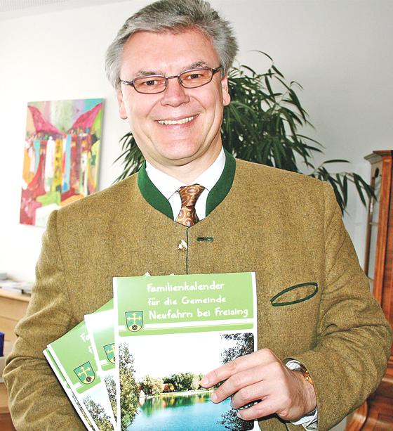 Neufahrns Erster Bürgermeister Rainer Schneider präsentierte im Rathaus den neuen Familienkalender 2014.	Foto: ws