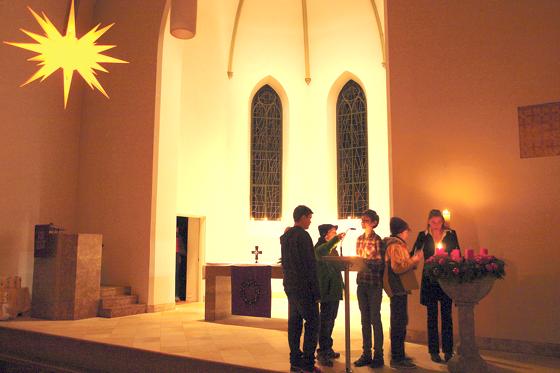 Pfarrerin Ursula Schwager entzündet gemeinsam mit den Konfirmanden von St. Paulus die erste Kerze am Adventskranz.	Foto: Rebeca Cabrerizo Keil